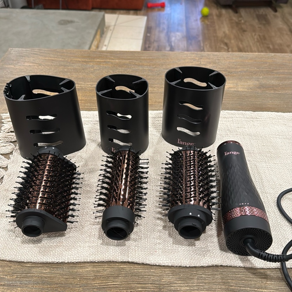 Black & rose gold L’ange blow dryer brush with three brush attachments.